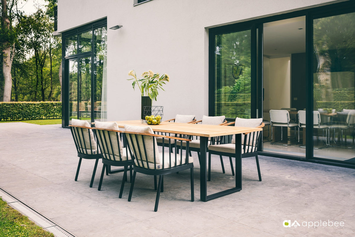 Condor garden chairs with aluminium frames and teak armrests around a table on the terrace, from the Dutch Garden collection