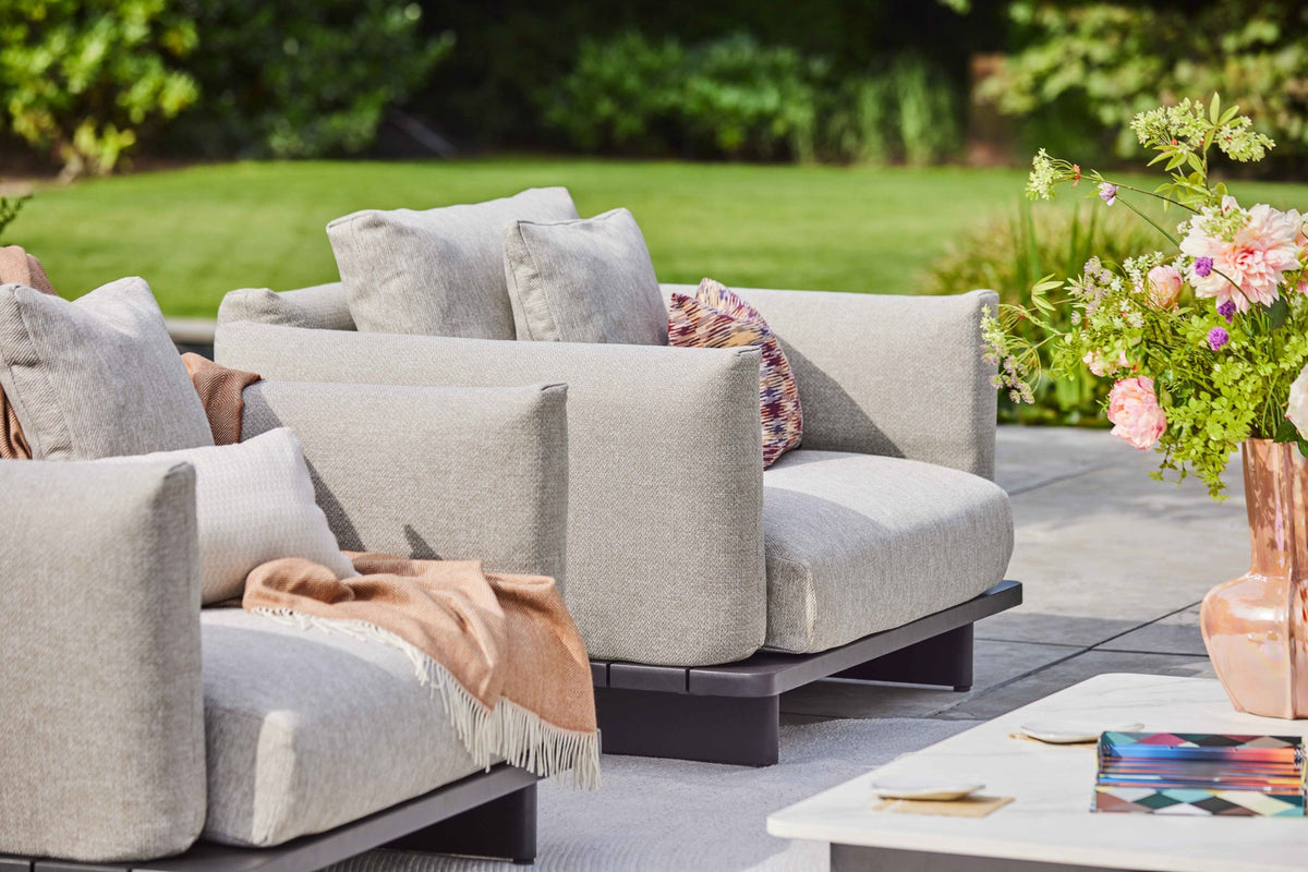 Volar-Loungegruppe mit hellen Sitz- und Rückenkissen auf einer Terrasse mit Pflanzen und Blumen, aus der Dutch-Garden-Kollektion